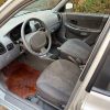 Interior Hyundai Accent gasolina LC 1.3 con asientos grises, volante y palanca de cambios en buen estado