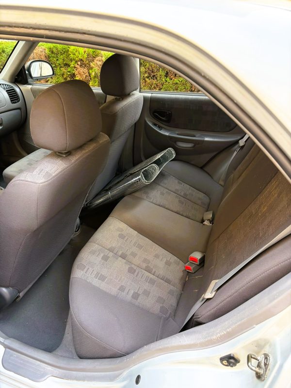 Interior trasero Hyundai Accent gasolina LC 1.3 con asientos de tela grises en buen estado