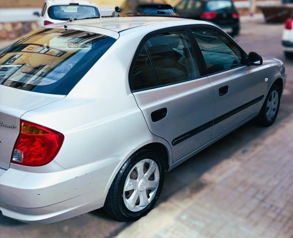 Hyundai Accent gasolina 1.3 LC color plata, vista trasera lateral, compacto sedán en perfecto estado